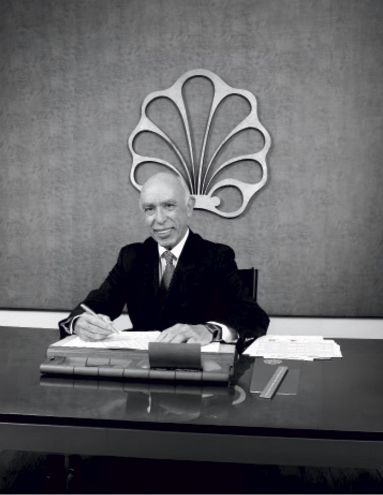 Dr. Adolpho Lindenberg em seu escritório, sob o brasão da marca